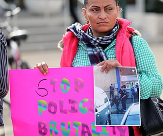Latina holding 'Stop Police Brutality' sign in Salinas, CA
