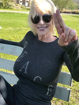 Peace t-shirt worn by woman flashing unity hand sign